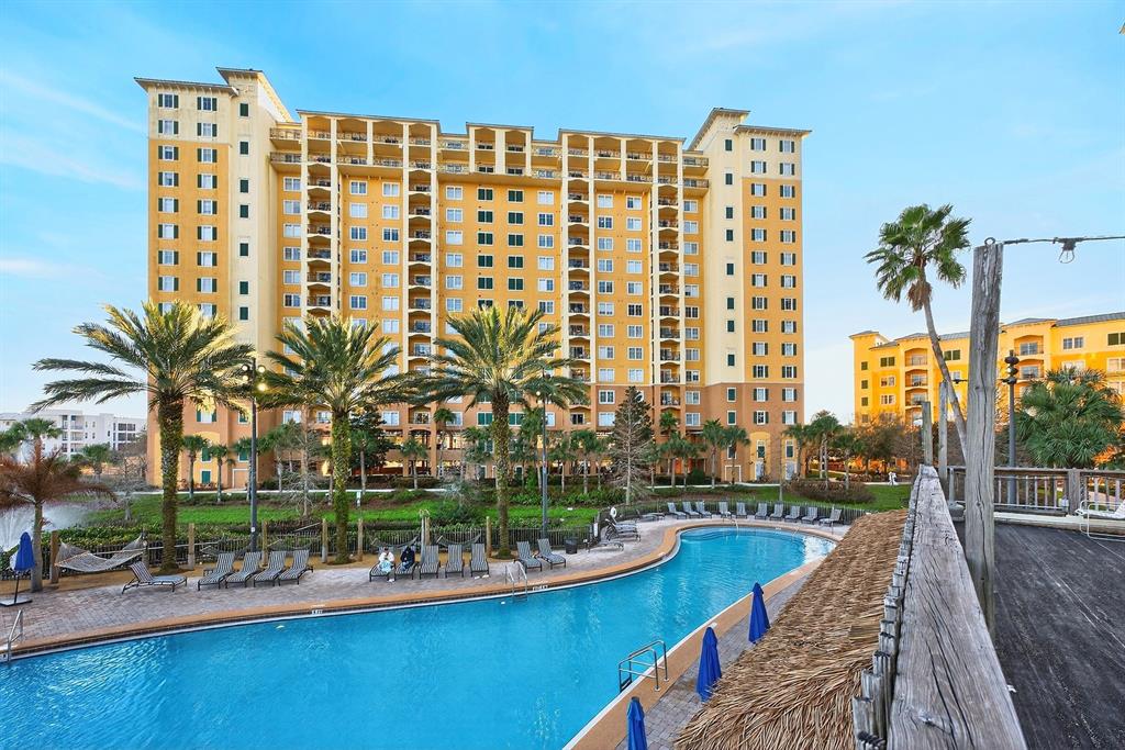 A large yellow multi-story resort building overlooks a swimming pool with lounge chairs and palms — 8125 RESORT VILLAGE DRIVE UNIT 5901, ORLANDO, FL