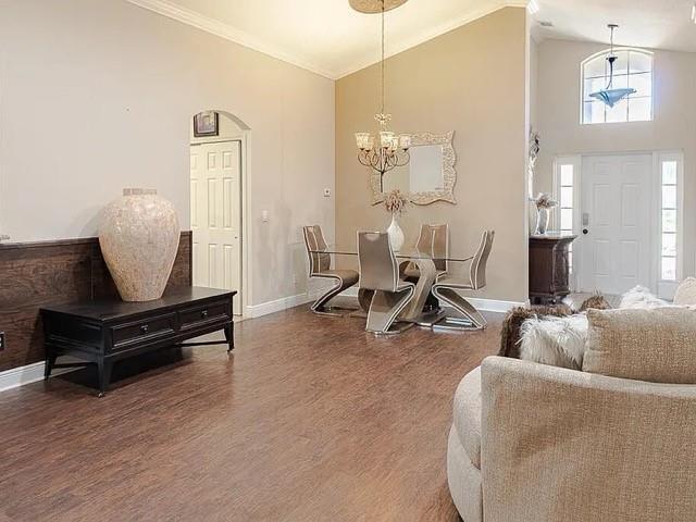 A dining area with a glass table and chandelier sits near a living room entrance — 9446 Windrift Circle, Fort Pierce FL 34945, FORT PIERCE, FL