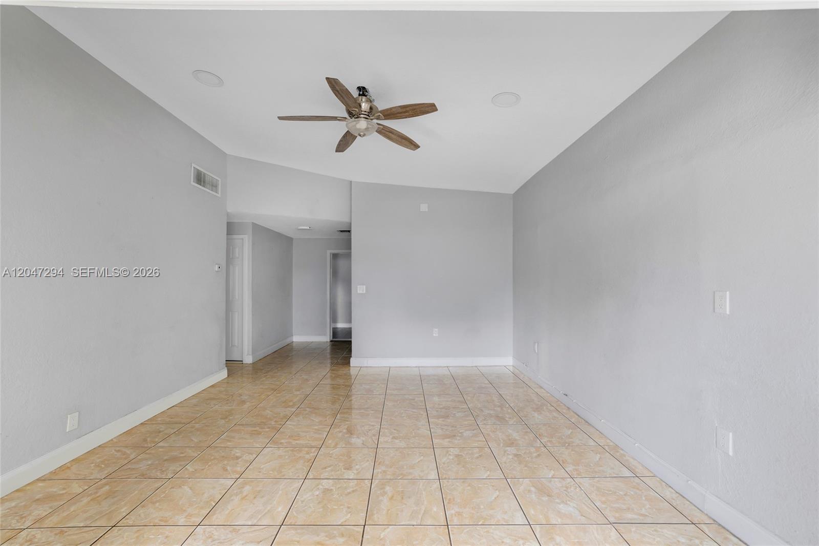 An empty room features light gray walls, tan tile flooring, and a ceiling fan — 18100 NW 7th Pl, Miami Gardens FL 33169, MIAMI GARDENS, FL