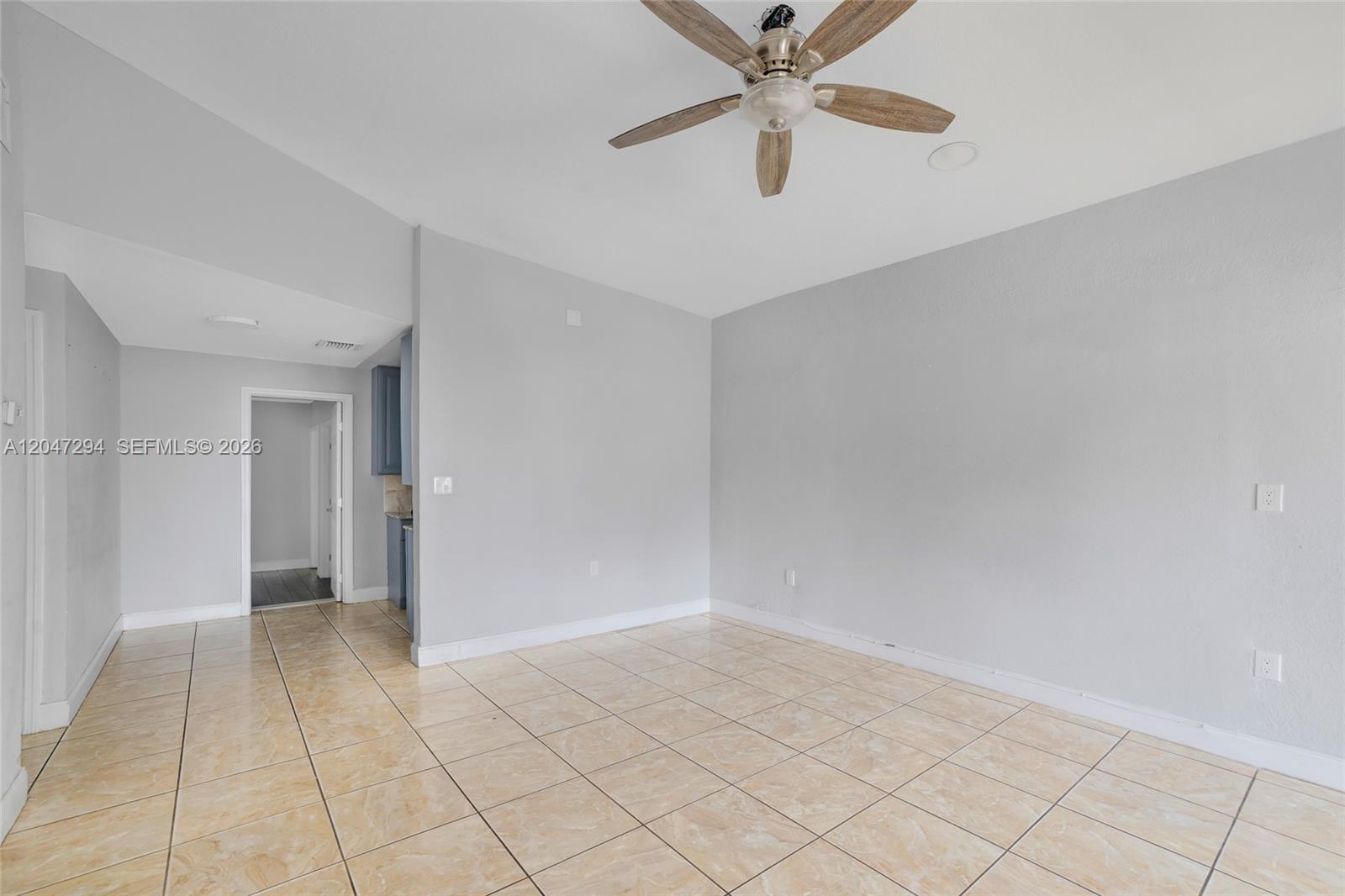 An empty room features light-colored tile flooring, gray walls, and a ceiling fan — 18100 NW 7th Pl, Miami Gardens FL 33169, MIAMI GARDENS, FL