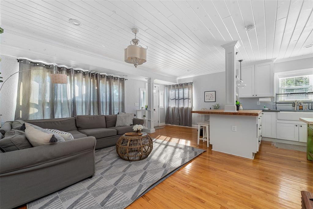 An open-concept living room and kitchen featuring hardwood floors, white plank ceilings, and gray furniture — 2007 CORNELL AVENUE, WINTER PARK, FL