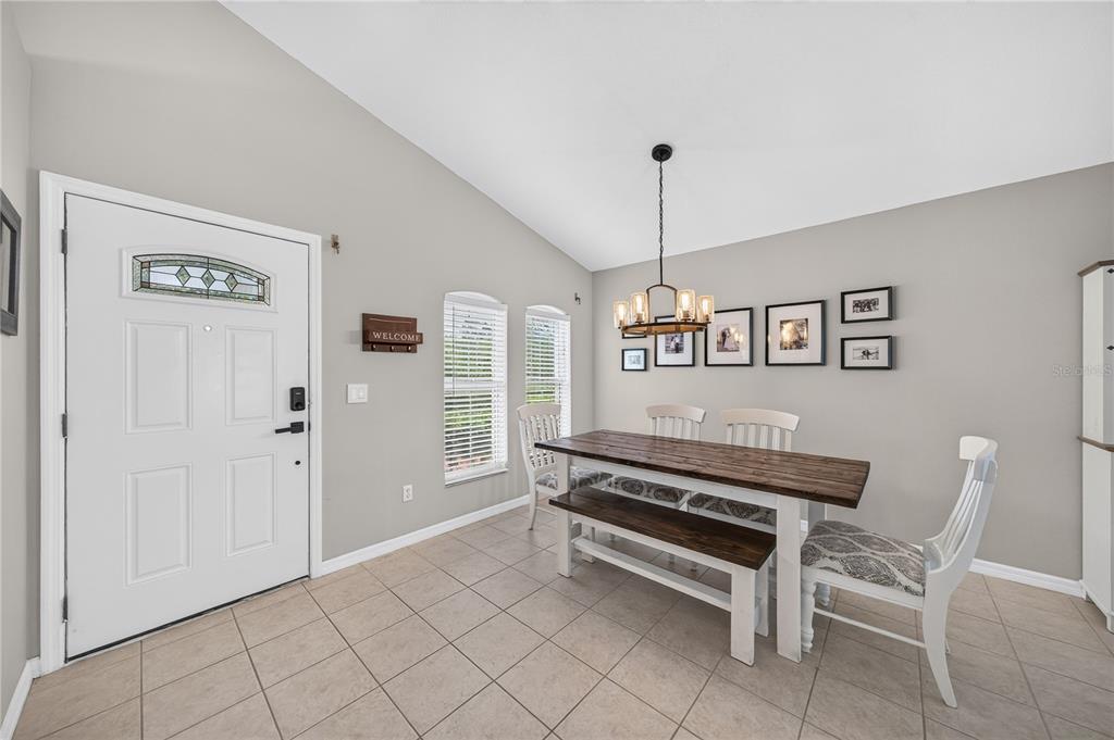 A dining area features a wooden table with a bench and chairs under a chandelier — 14001 FAIRWINDS COURT, ORLANDO, FL