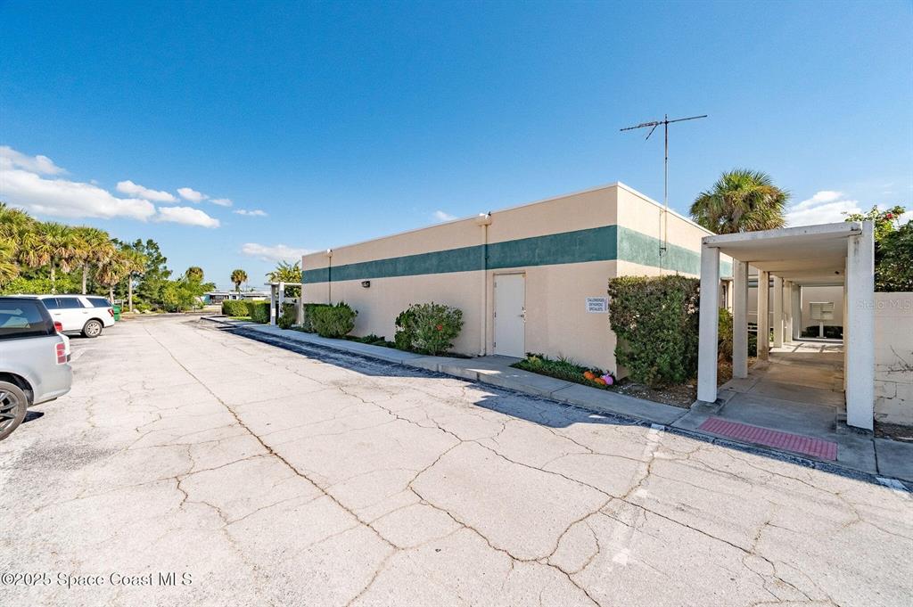 A single-story commercial building with a beige exterior, green stripe, and a covered walkway — 333 W COCOA BEACH CAUSEWAY UNIT 5, COCOA BEACH, FL