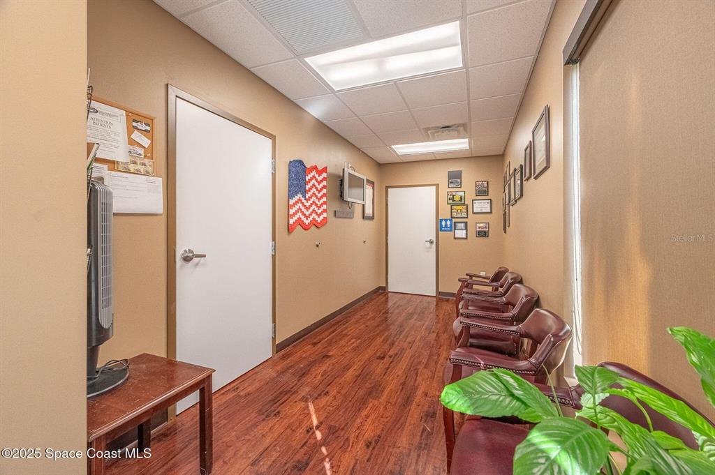 A waiting room features wood-look flooring, tan walls, several chairs, and a white door — 333 W COCOA BEACH CAUSEWAY UNIT 5, COCOA BEACH, FL