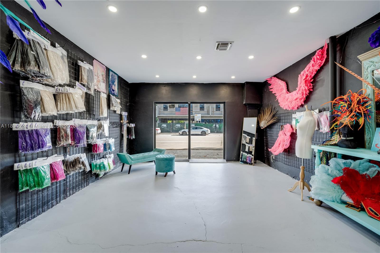 A retail space features black walls, a light gray floor, and displays of colorful feathers — 2900 NW 11th Ave, Miami FL 33127, MIAMI, FL