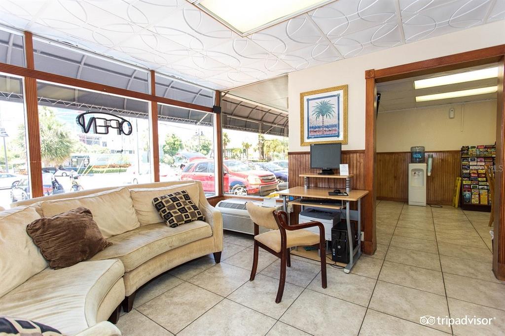 A waiting area features a beige sofa, a computer desk, and large windows with exterior views — 504 S GULFVIEW BOULEVARD, CLEARWATER, FL