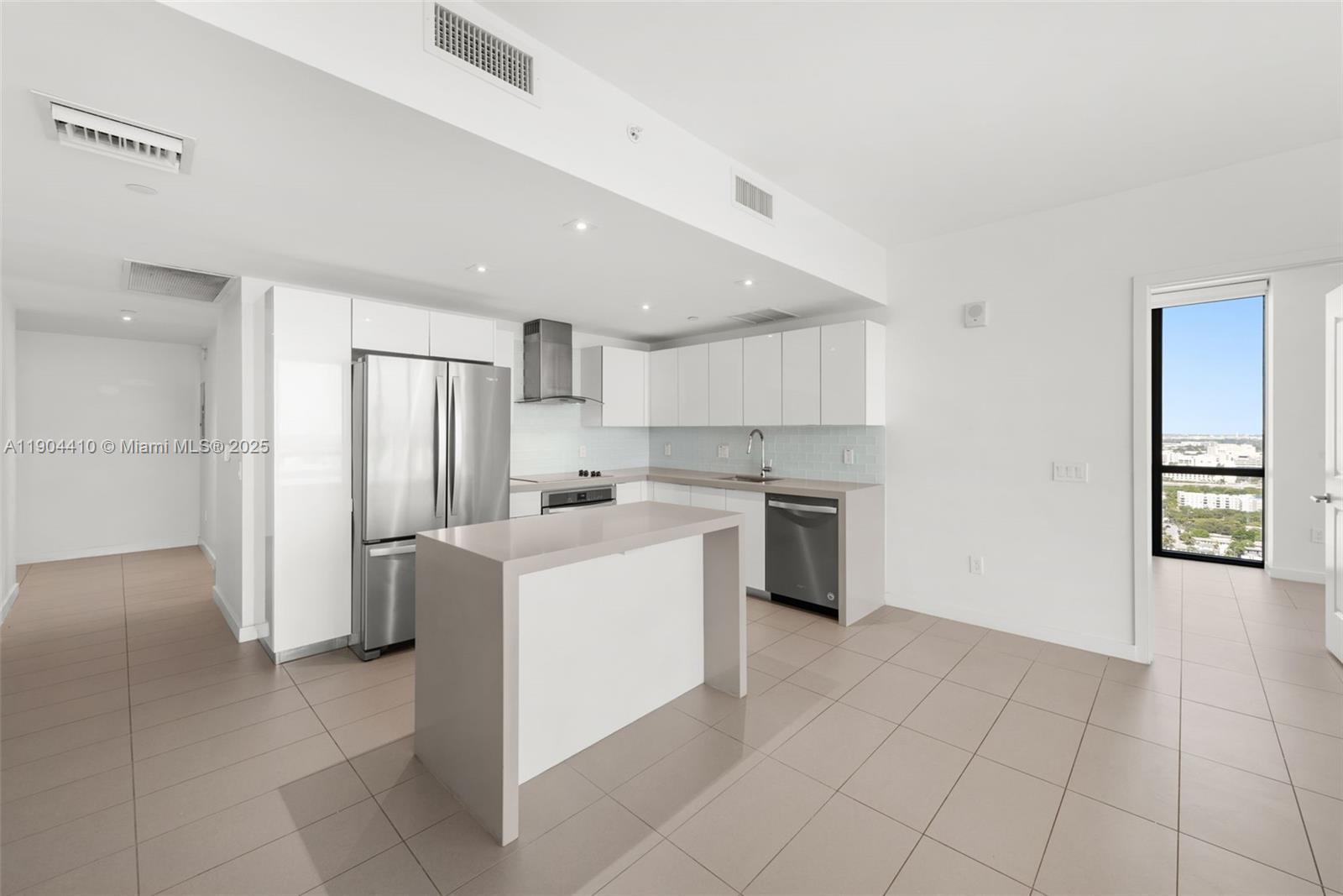 A modern kitchen features white cabinets, stainless steel appliances, a central island, and tile flooring — 1600 NE 1st Ave # 3016, Miami FL 33132, MIAMI, FL