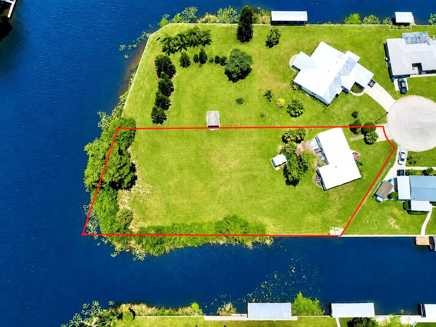 An aerial view shows a waterfront residential lot outlined in red with a house — 2717 SE 32nd Street, Okeechobee FL 34974, OKEECHOBEE, FL