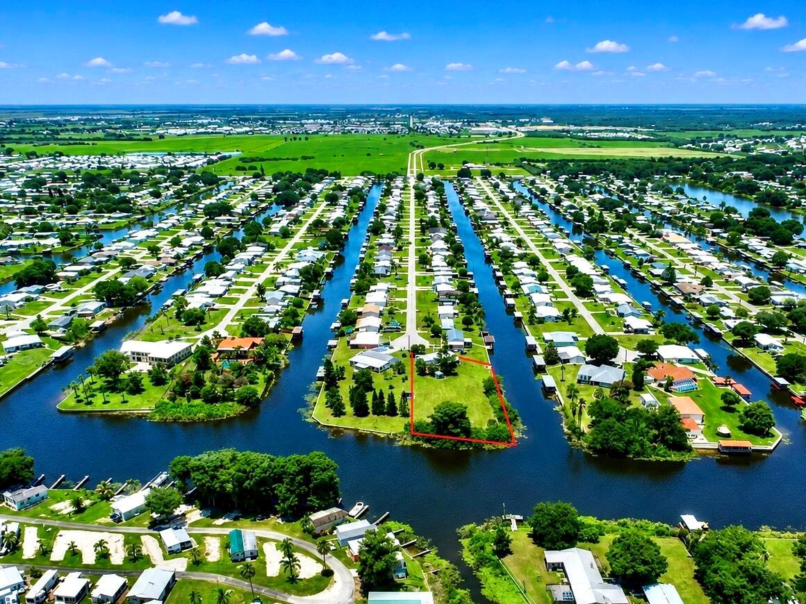 An aerial view shows a waterfront residential lot outlined in red within a canal community — 2717 SE 32nd Street, Okeechobee FL 34974, OKEECHOBEE, FL