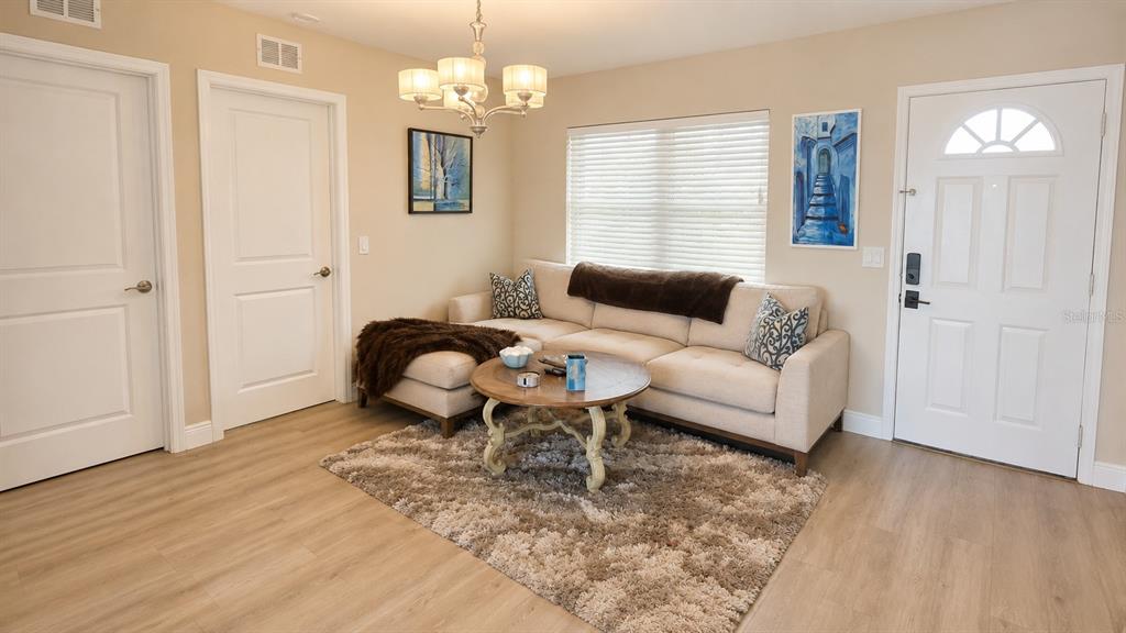 A living room features a beige sectional sofa, a round wooden coffee table, and light-colored flooring — 526 20TH AVENUE, INDIAN ROCKS BEACH, FL