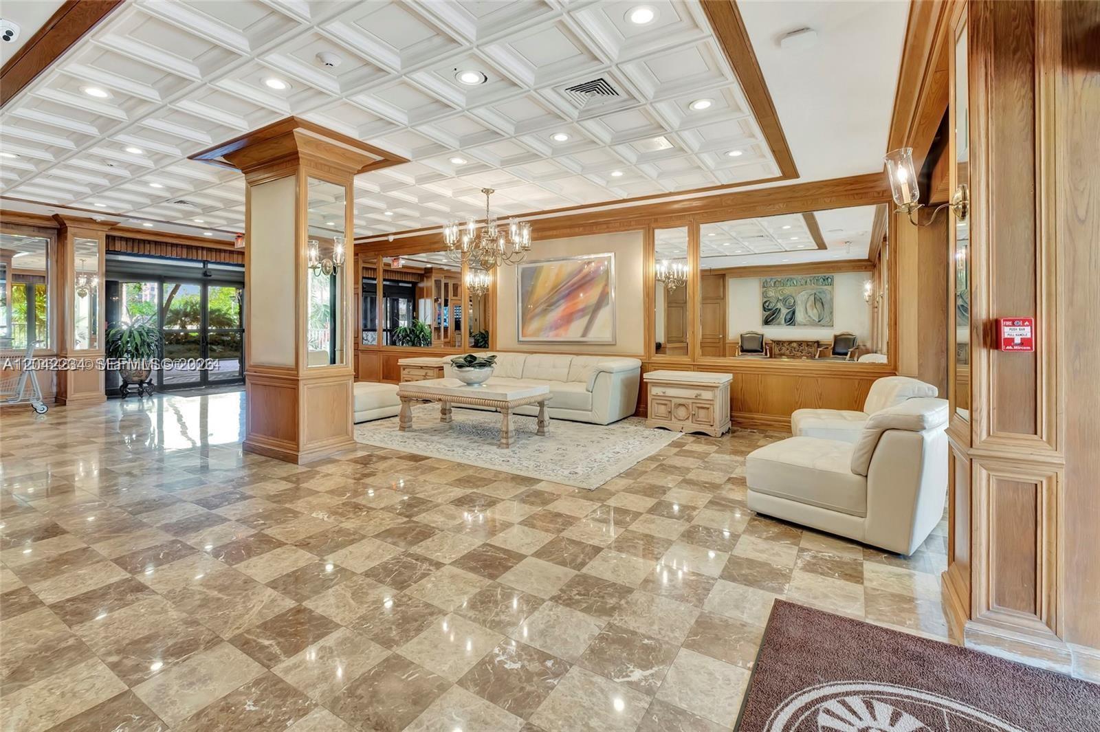 A lobby features a coffered ceiling, checkered marble floors, wood paneling, and white leather furniture — 11111 Biscayne Blvd, Miami FL 33181, MIAMI, FL