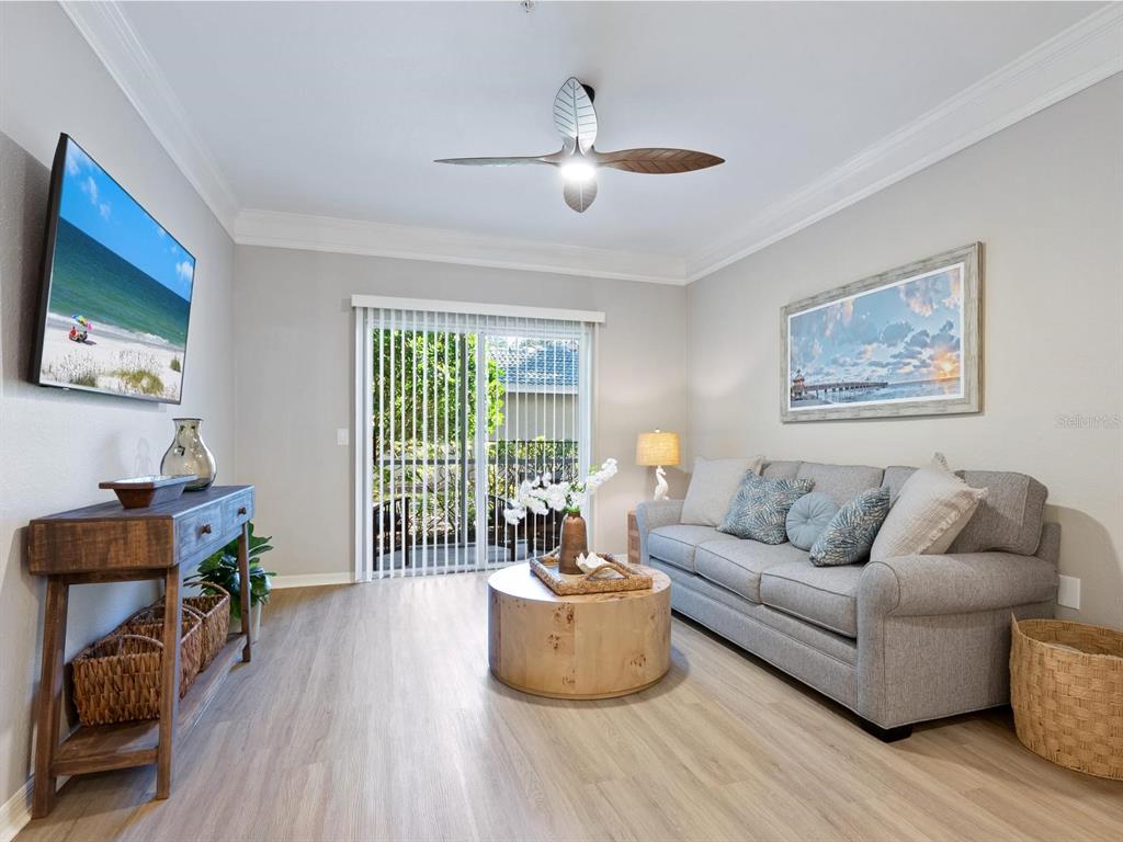 A living room features a gray sofa, a wooden coffee table, and a ceiling fan — 5168 NORTHRIDGE ROAD UNIT 102, SARASOTA, FL
