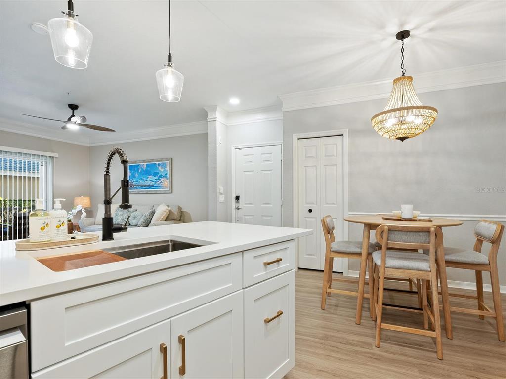 A kitchen island with a sink overlooks a dining area and a living room — 5168 NORTHRIDGE ROAD UNIT 102, SARASOTA, FL
