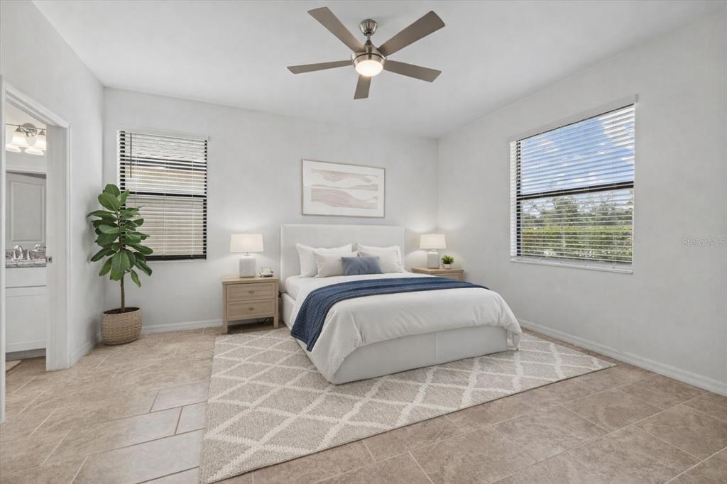 A bedroom features a white bed, a ceiling fan, two windows, and light-colored tile flooring — 2081 GARDENIA AVENUE, PORT CHARLOTTE, FL