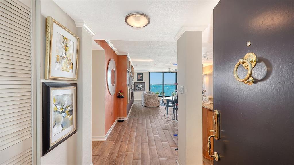 An entryway leads into a living area with wood-look flooring and a view of water — 707 S GULFSTREAM AVENUE UNIT 705, SARASOTA, FL