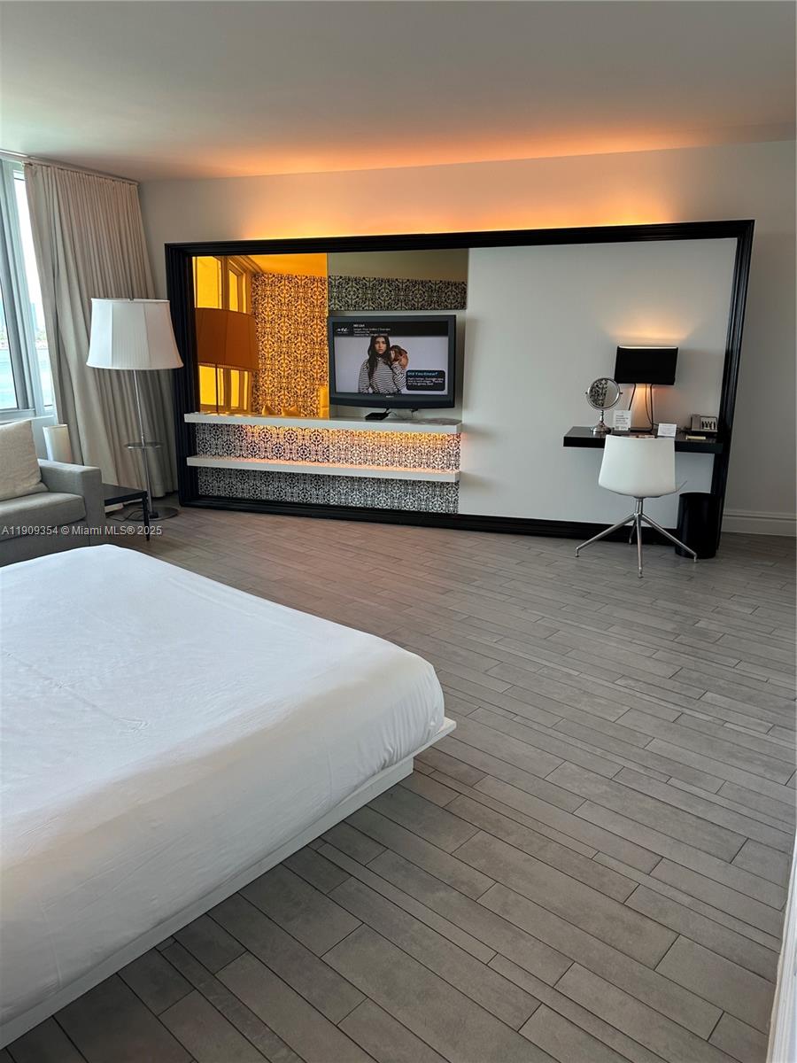 A bedroom features a platform bed, a wall-mounted television, and a built-in desk area — 1100 West Ave # 1206, Miami Beach FL 33139, MIAMI BEACH, FL