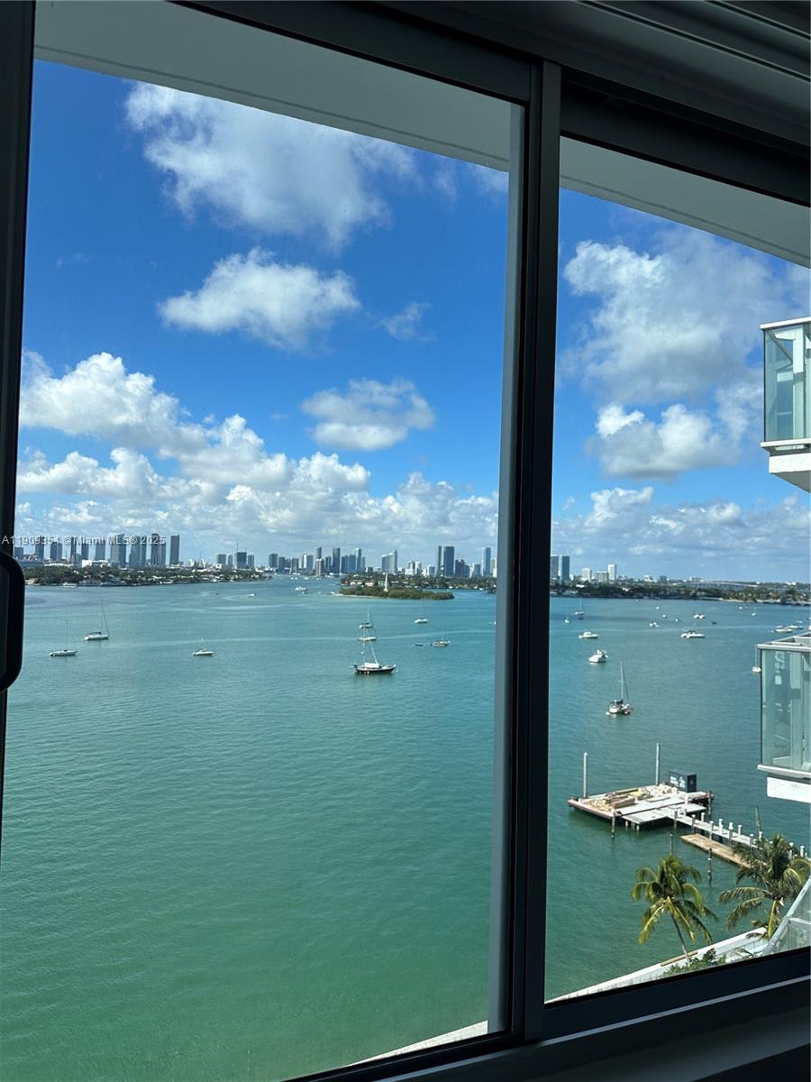 A view of a bay with boats and a city skyline seen through a window — 1100 West Ave # 1206, Miami Beach FL 33139, MIAMI BEACH, FL