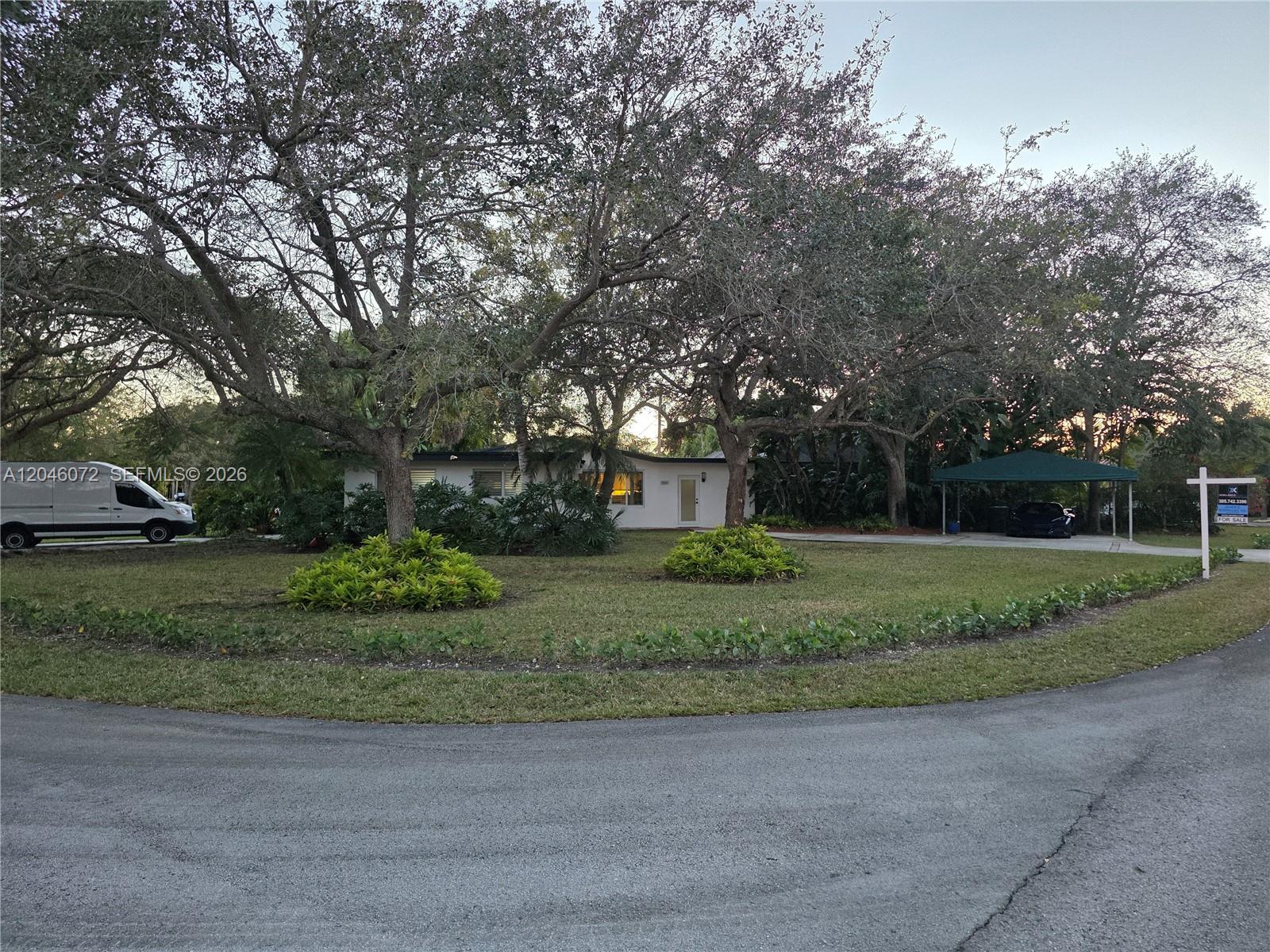 A single-story house with a large lawn, mature trees, and a carport — 9860 SW 140th St, Miami FL 33176, MIAMI, FL
