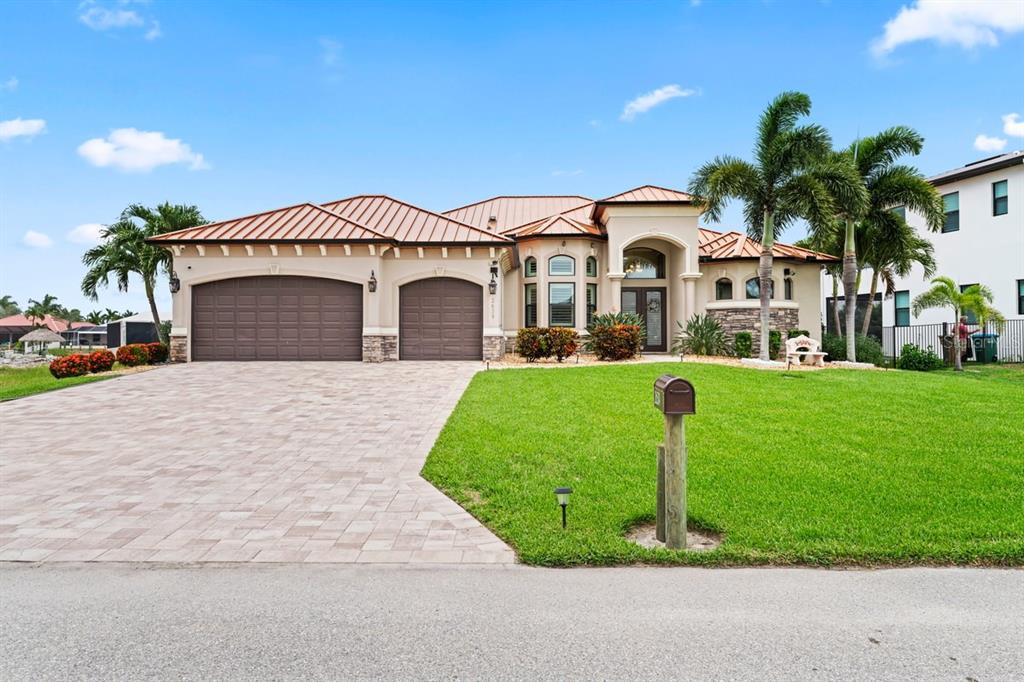 A single-story house with a metal roof, two-car garage, and a paved driveway — 2639 SW 29TH AVENUE, CAPE CORAL, FL