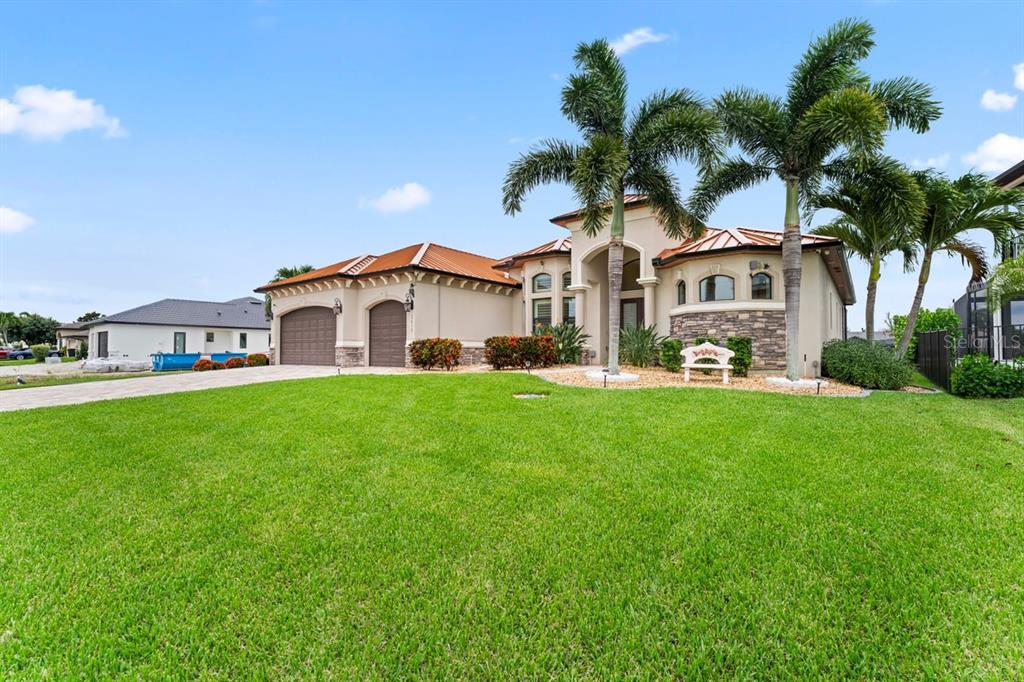 A single-story house with a tile roof, two-car garage, and palm trees in the front yard — 2639 SW 29TH AVENUE, CAPE CORAL, FL