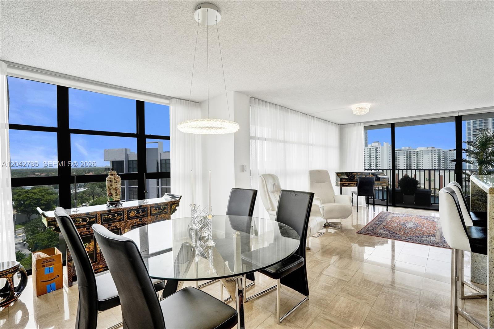 A dining area with a glass table and black chairs overlooks a city skyline view — 400 Leslie Dr # 1110, Hallandale Beach FL 33009, HALLANDALE BEACH, FL