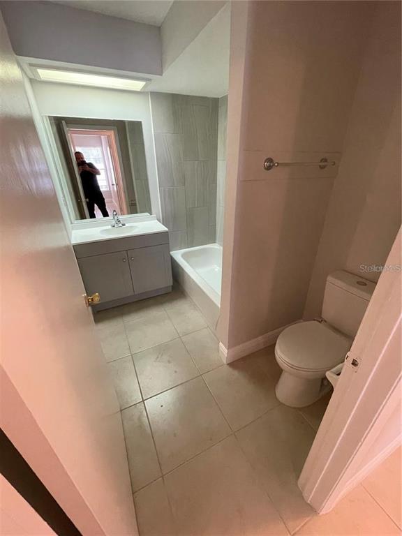 A bathroom features a vanity with a sink, a tiled bathtub, and a toilet — 1916 CRYSTAL GROVE DRIVE, LAKELAND, FL