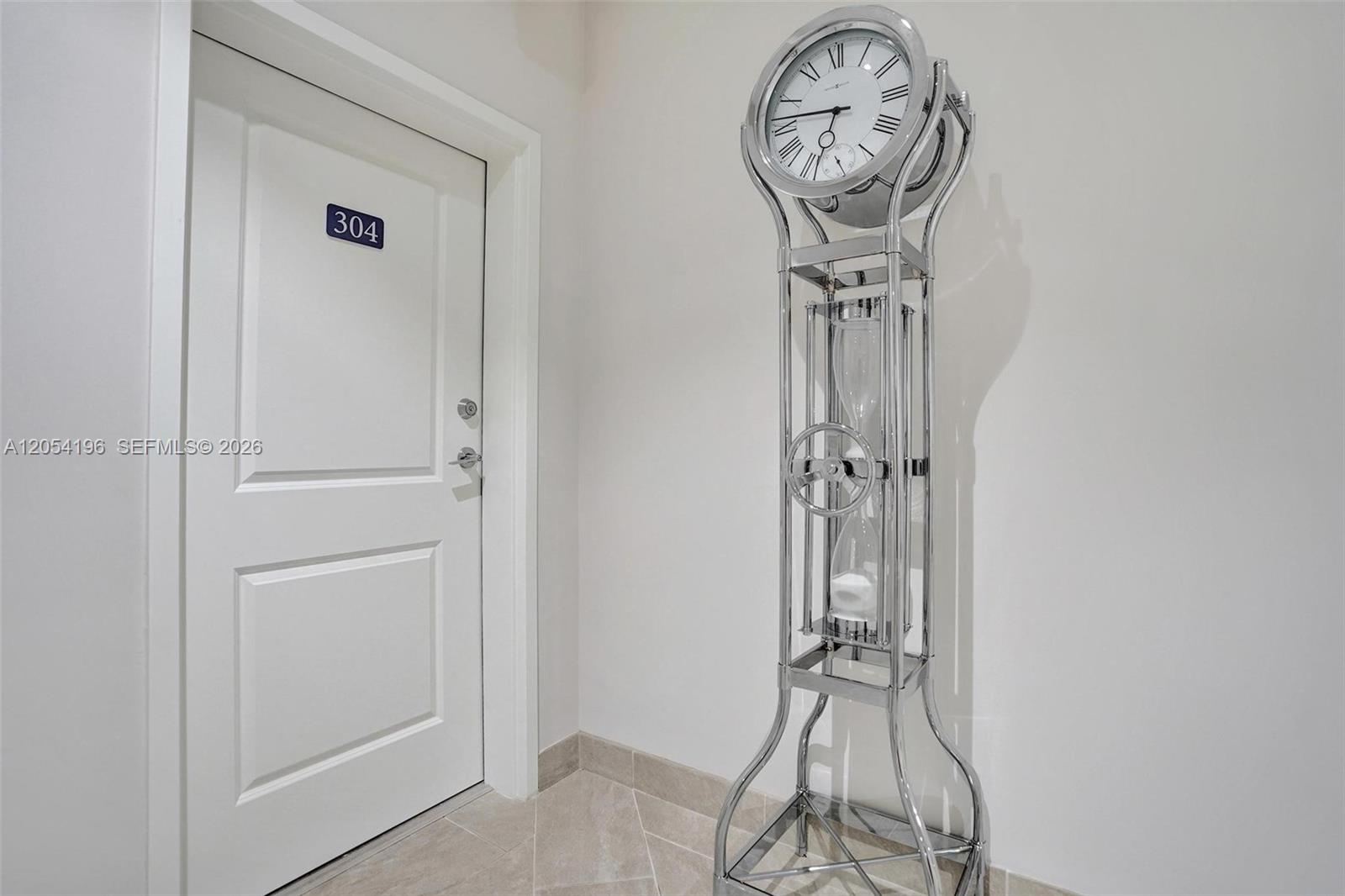 A white door labeled 304 stands next to a tall, silver, modern grandfather clock — 41 SW Seminole St # 310, Stuart FL 34994, STUART, FL