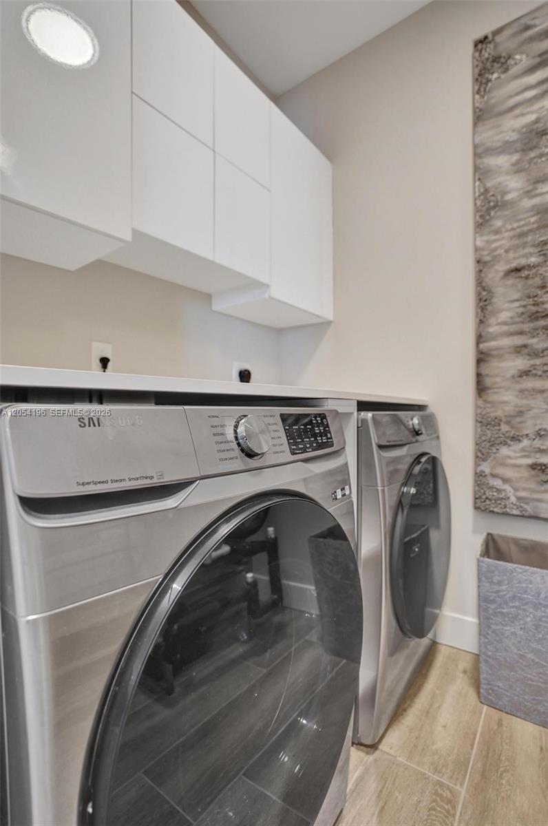 A laundry room features stainless steel Samsung appliances, white upper cabinets, and light-colored tile flooring — 41 SW Seminole St # 310, Stuart FL 34994, STUART, FL