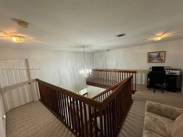 A carpeted loft area features a wooden staircase railing, a chandelier, and a desk setup — 3537 SW 175th Avenue, Miramar FL 33029, MIRAMAR, FL