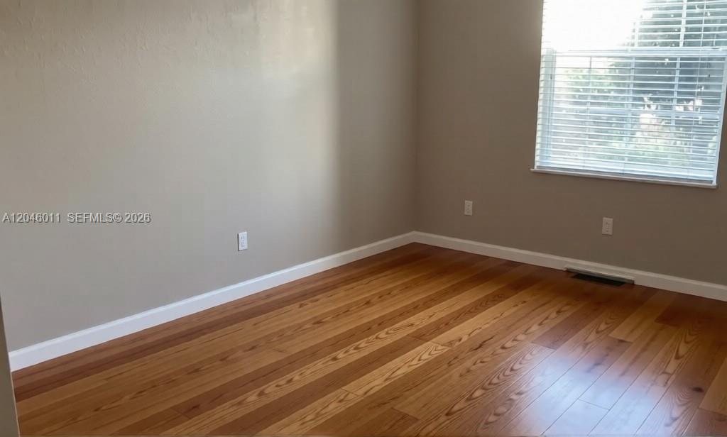 An empty room features light-colored walls, hardwood flooring, and a window with white blinds — 2788 Almaton Loop # 0, Kissimmee FL 34747, KISSIMMEE, FL