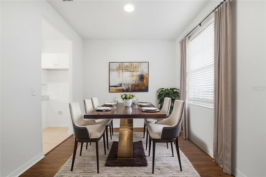 A dining room features a dark wood table with a gold base and six chairs — 20506 CAROLINA CHERRY COURT, TAMPA, FL