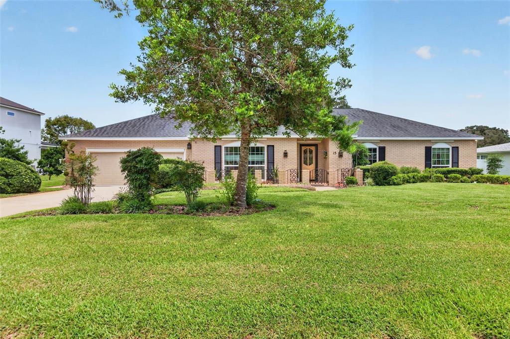 A single-story brick house with a two-car garage and a large front lawn — 15 OAKMONT CIRCLE, ORMOND BEACH, FL