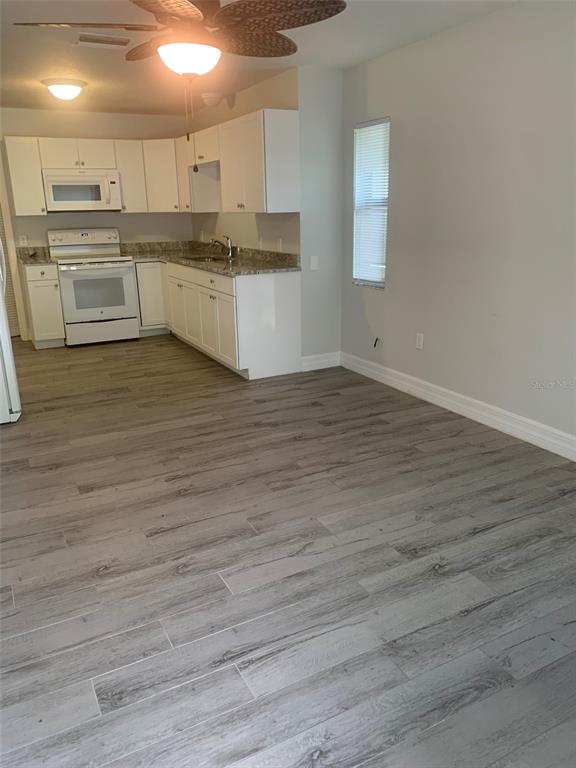 A single-story house with a brown garage door, arched entryway, and a small front garden — 11452 OCEANSPRAY AVENUE, ENGLEWOOD, FL