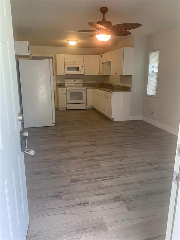 A single-story house features a brown garage door, a covered entryway, and a grassy lawn — 11452 OCEANSPRAY AVENUE, ENGLEWOOD, FL