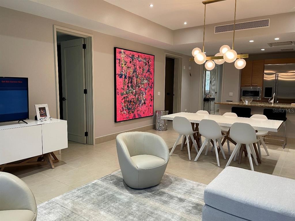 A modern living and dining area features a large pink abstract painting and white furniture — 7000 Bahia Beach Blvd LAS VERANDAS CONDOMINIUM UNIT 4128, RIO GRANDE, PR