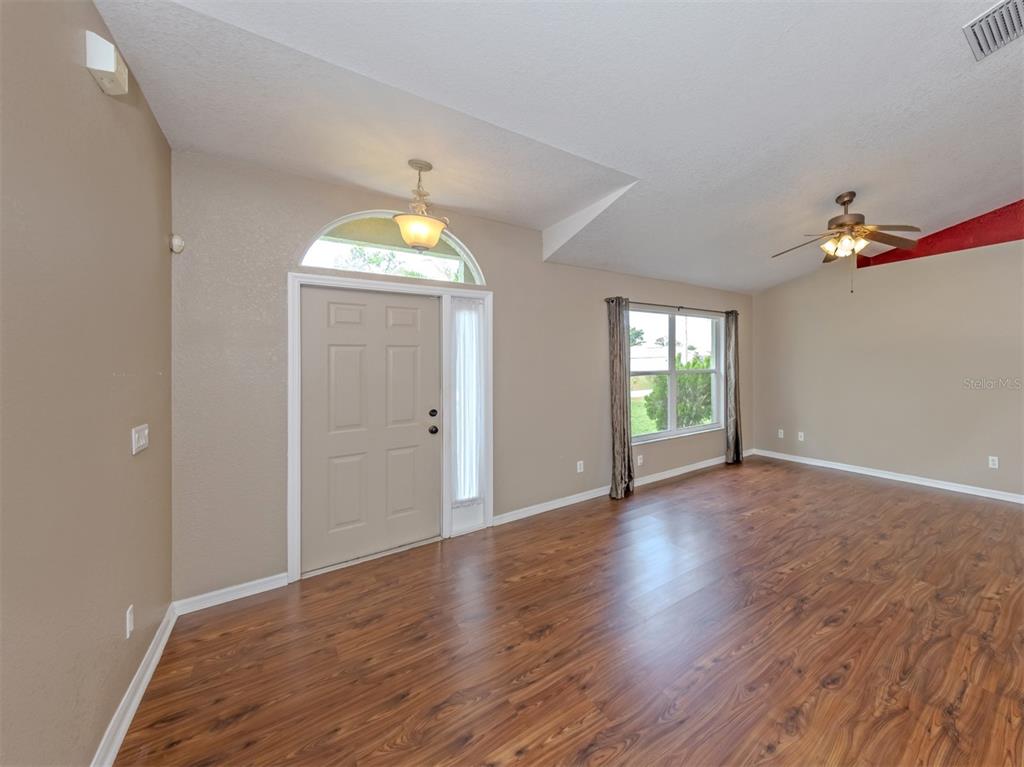 An entryway with wood-look flooring, a front door with a transom window, and a ceiling fan — 2136 PENGUIN LANE, NORTH PORT, FL