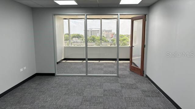 An office room features gray carpet, white walls, and a glass-walled balcony door — 654 MUÑOZ RIVERA, SAN JUAN, PR