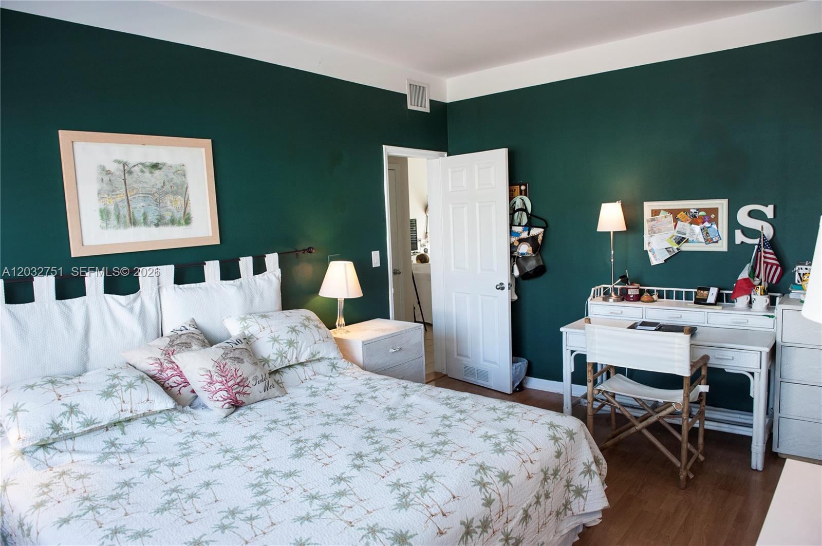 A bedroom features dark green walls, a white bed with palm-print bedding, and a desk — 1840 James Ave # 10, Miami Beach FL 33139, MIAMI BEACH, FL