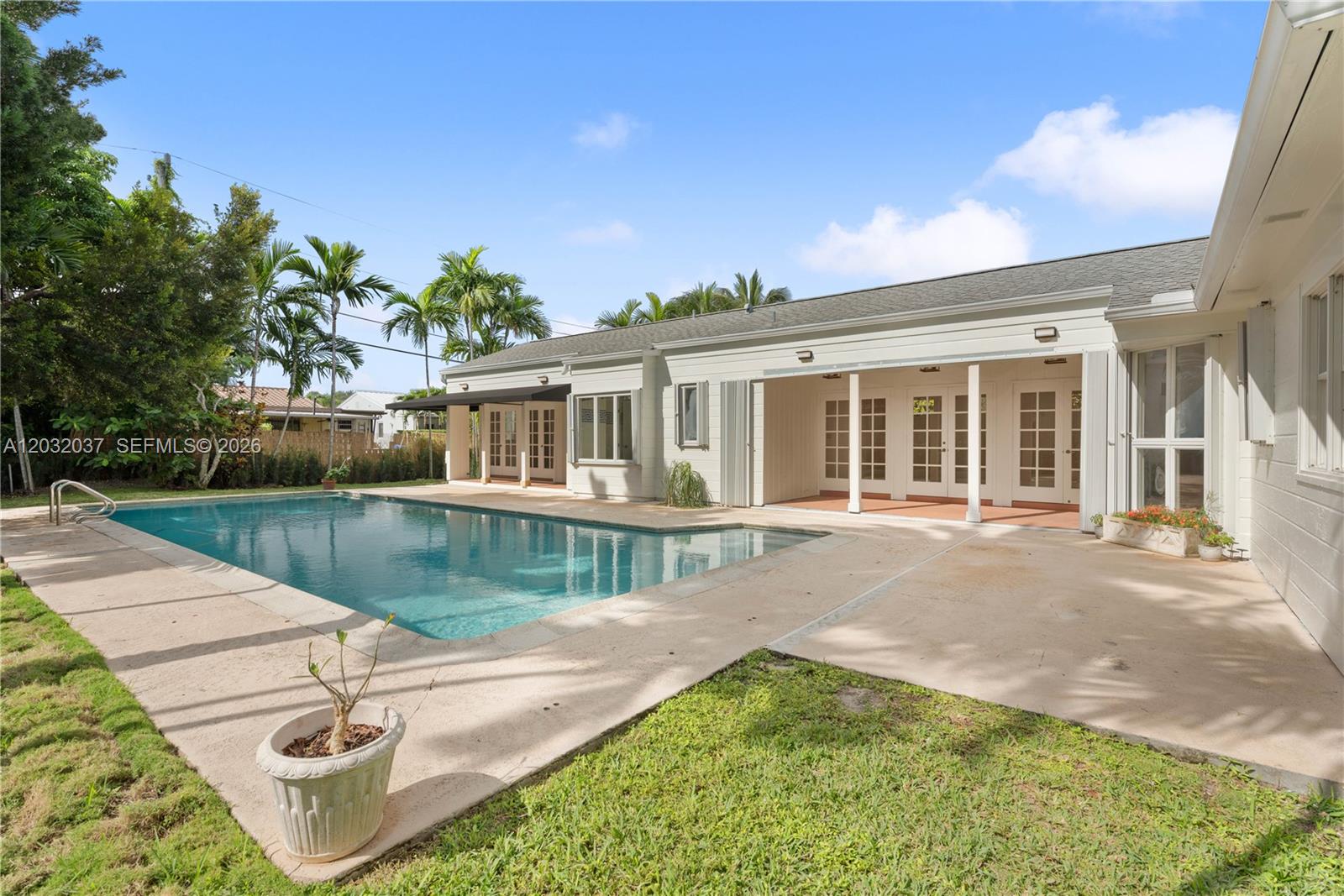 A backyard features a rectangular swimming pool, a concrete patio, and a single-story house exterior — 440 SW 29th Rd, Miami FL 33129, MIAMI, FL