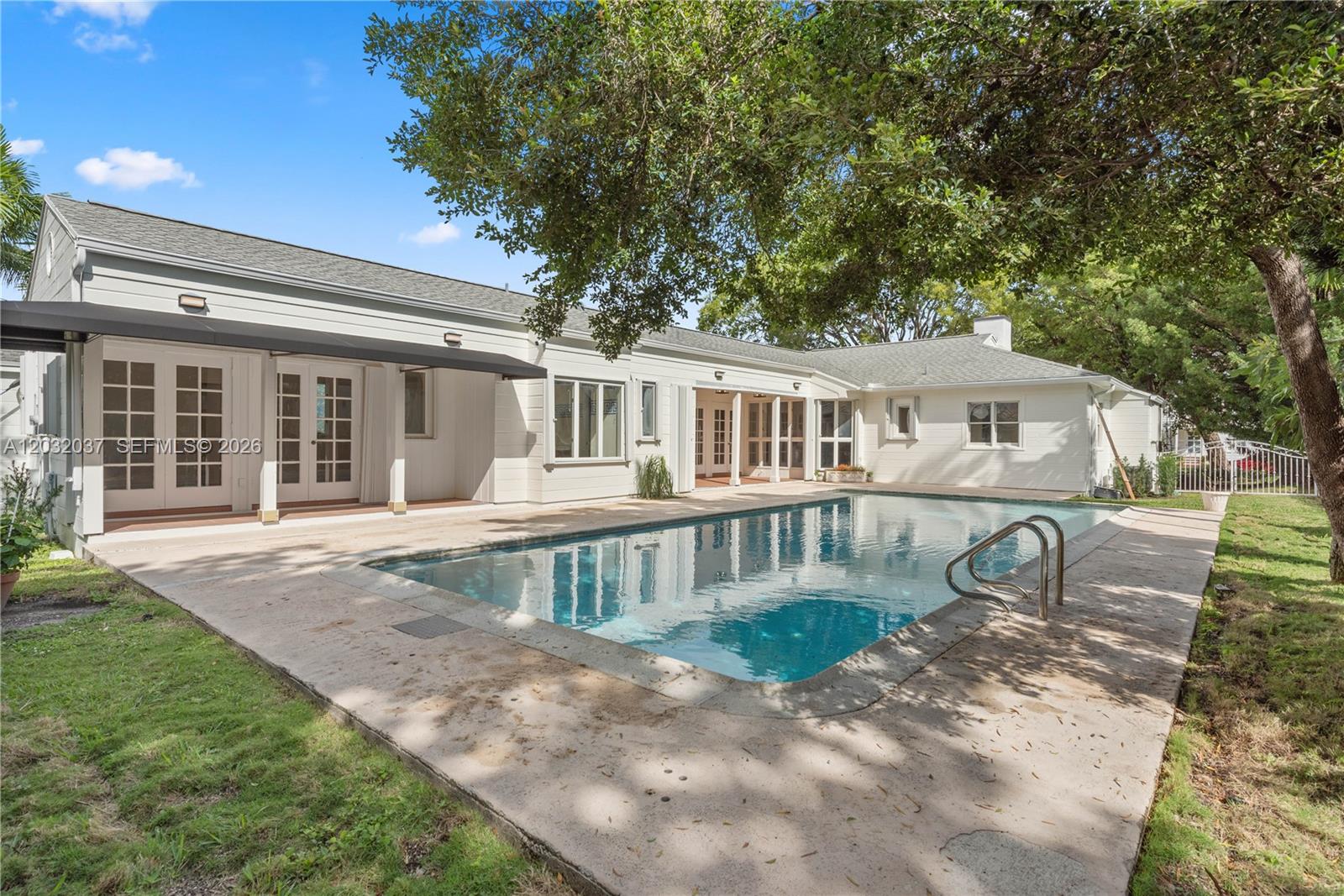 A white single-story house features a swimming pool and a concrete patio in the backyard — 440 SW 29th Rd, Miami FL 33129, MIAMI, FL