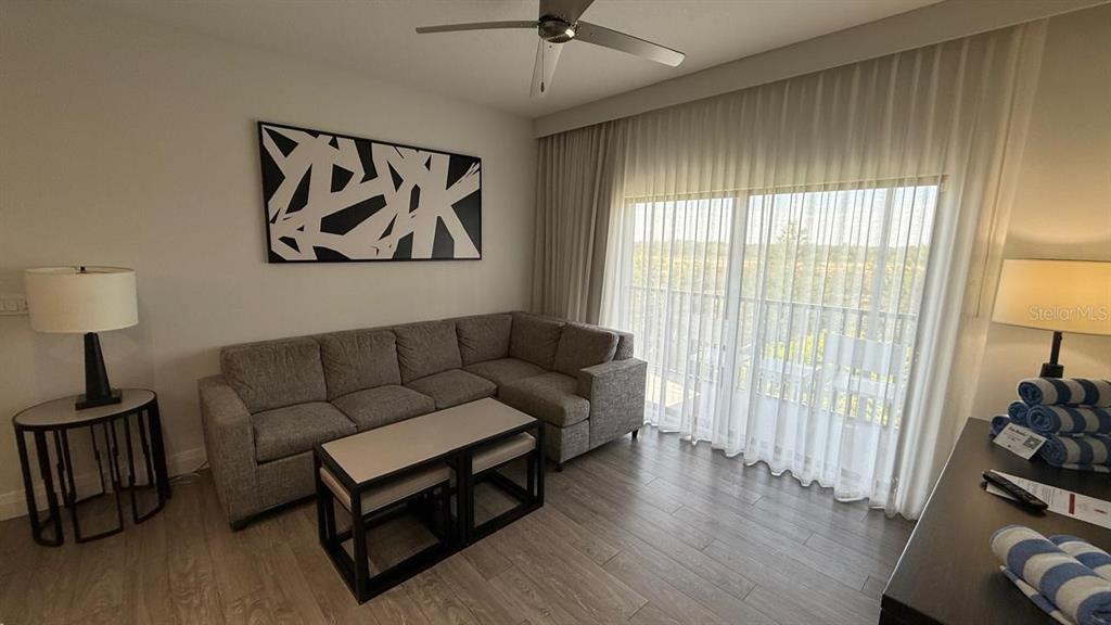 A living room features a gray sectional sofa, a coffee table, and floor-to-ceiling curtains — 14501 GROVE RESORT AVENUE UNIT 3429, WINTER GARDEN, FL