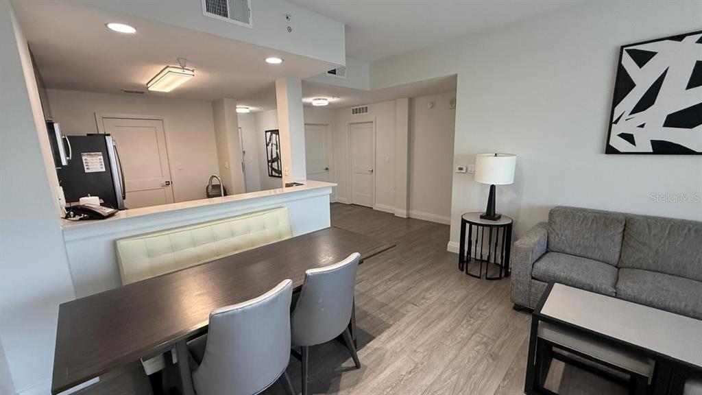 A dining area with a table and bench sits adjacent to a living room sofa — 14501 GROVE RESORT AVENUE UNIT 3429, WINTER GARDEN, FL