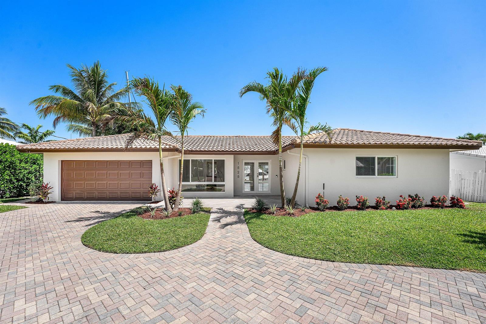 A single-story house with a paved driveway, palm trees, and a brown garage door — 1525 SE 6th Street, Deerfield Beach FL 33441, DEERFIELD BEACH, FL