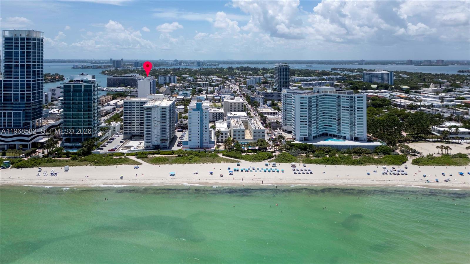 An aerial view shows a sandy beach, turquoise ocean, and several high-rise residential buildings — 401 69 ST # 411, Miami Beach FL 33141, MIAMI BEACH, FL