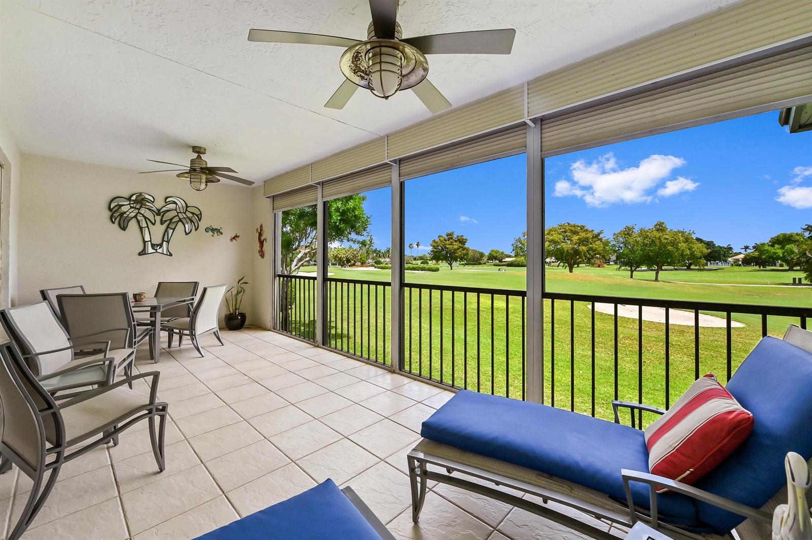 A screened-in patio features tile flooring, ceiling fans, and a view of a golf course — 11618 Briarwood Circle # 4, Boynton Beach FL 33437, BOYNTON BEACH, FL