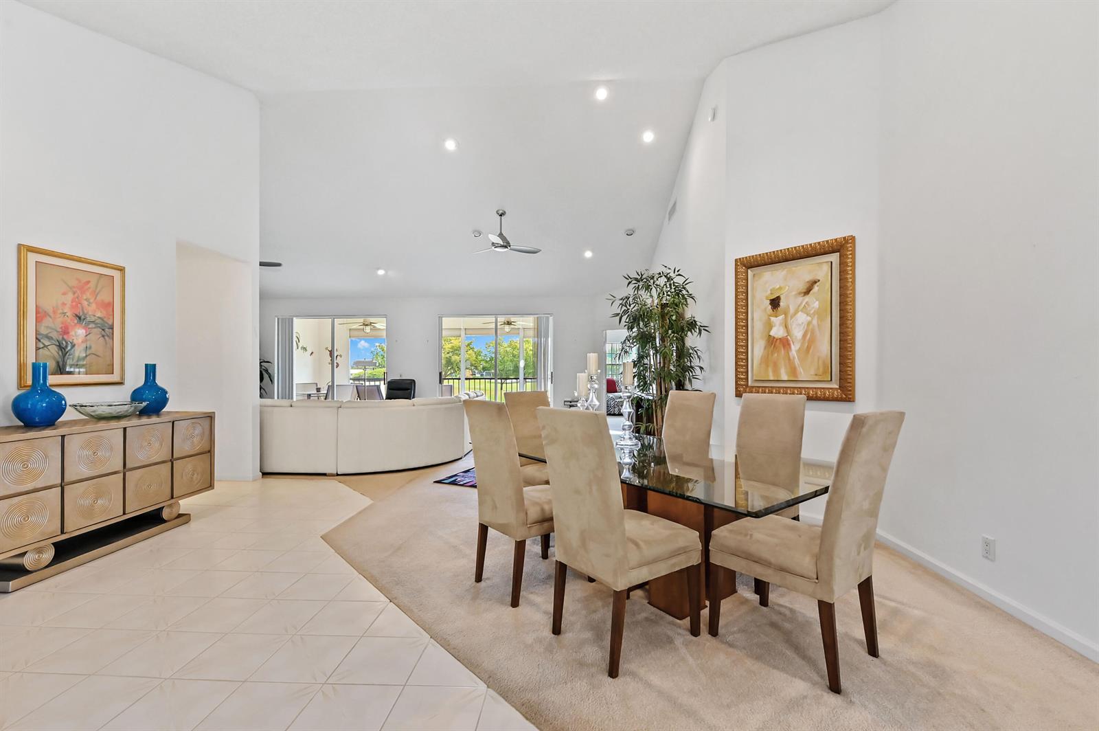 A dining area with a glass table and chairs sits adjacent to a living room — 11618 Briarwood Circle # 4, Boynton Beach FL 33437, BOYNTON BEACH, FL