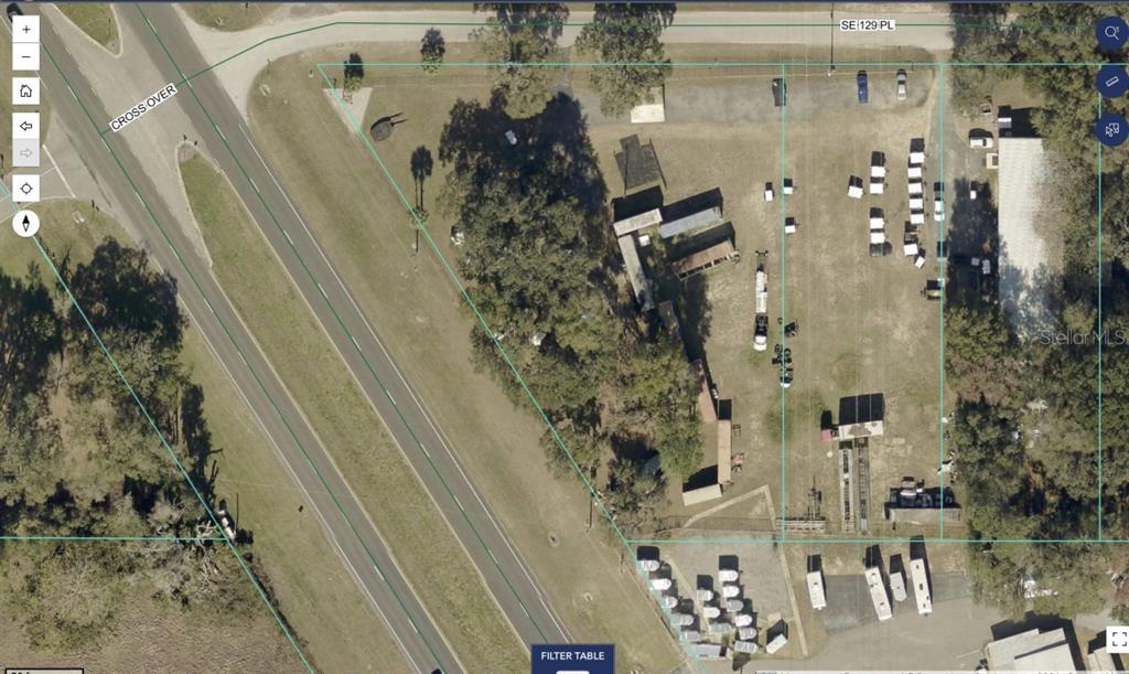 This aerial map shows a fenced commercial lot with multiple storage structures and parked vehicles — 7800 SE 129TH PLACE, SUMMERFIELD, FL