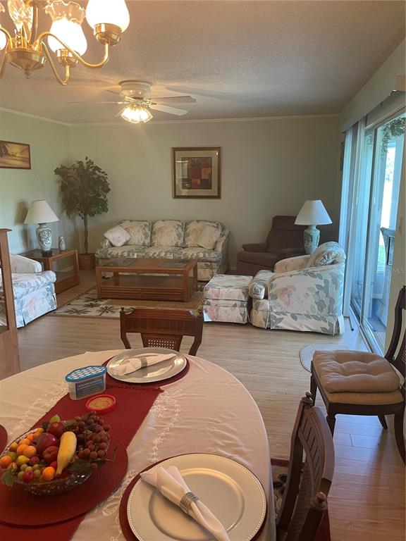 A dining area in the foreground opens into a living room with floral furniture — 532 MIDWAY DRIVE Unit A, OCALA, FL