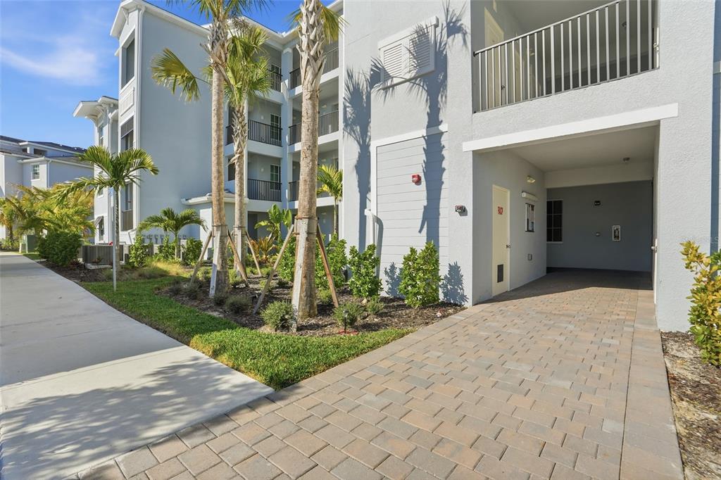 A paved driveway leads to the ground floor entrance of a multi-story apartment building — 14191 HERITAGE LANDING BOULEVARD UNIT 1234, PUNTA GORDA, FL