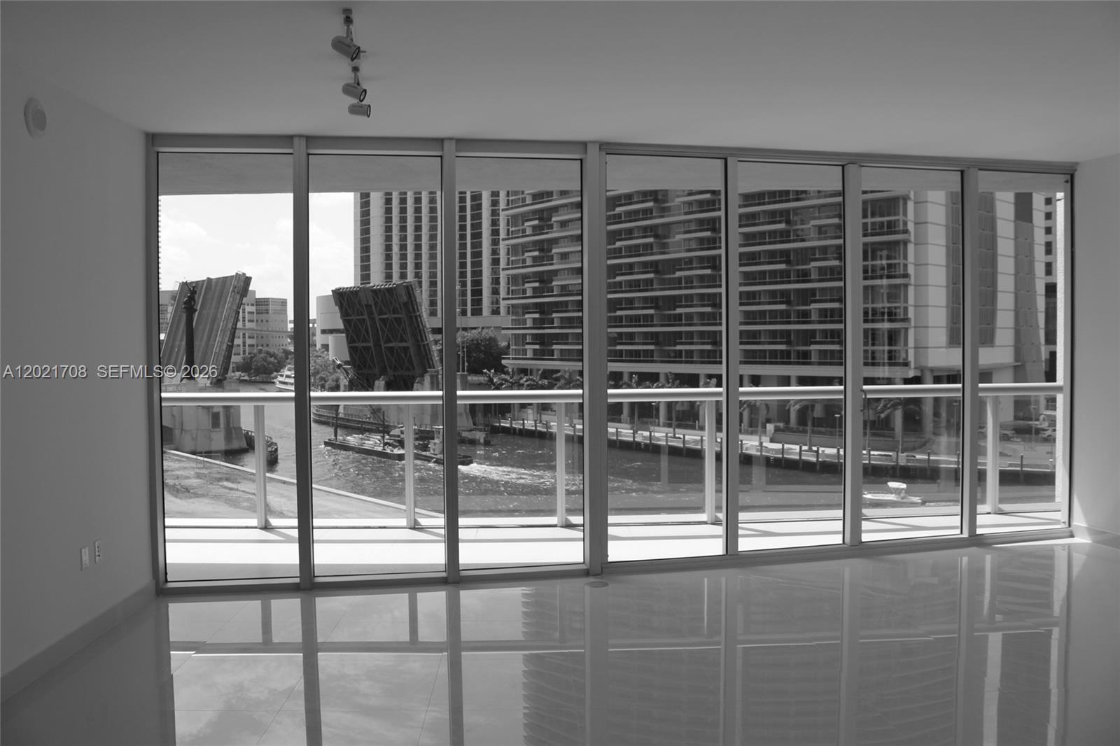 A bright room with floor-to-ceiling windows overlooks a city river and a drawbridge — 465 BRICKELL AV # 502, Miami FL 33131, MIAMI, FL